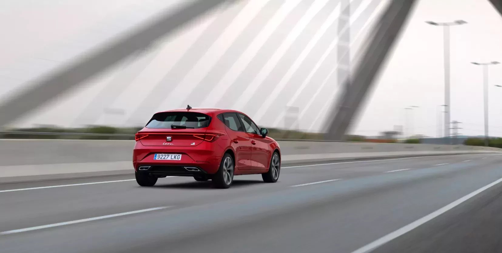 Czerwony Seat Leon PHEV FR w ruchu na ulicy